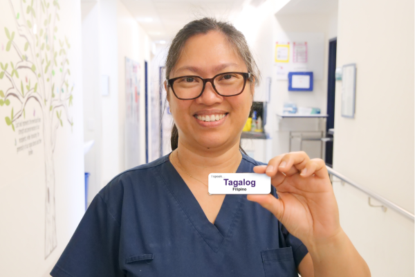 Austin Health staff member holding up Tagalog language badge as part of the Language Skills Badge Program